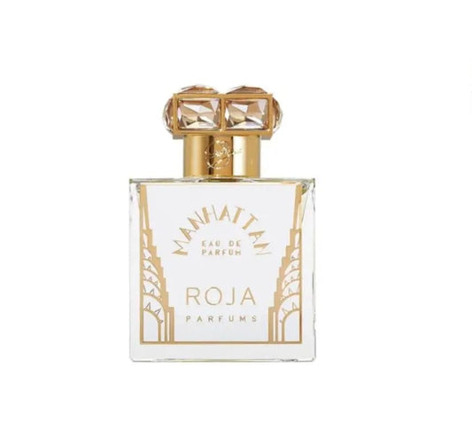 A clean, front-facing product shot of the Roja Parfums Manhattan perfume bottle. The image highlights the bottle's intricate design and the distinctive gold cap and label.